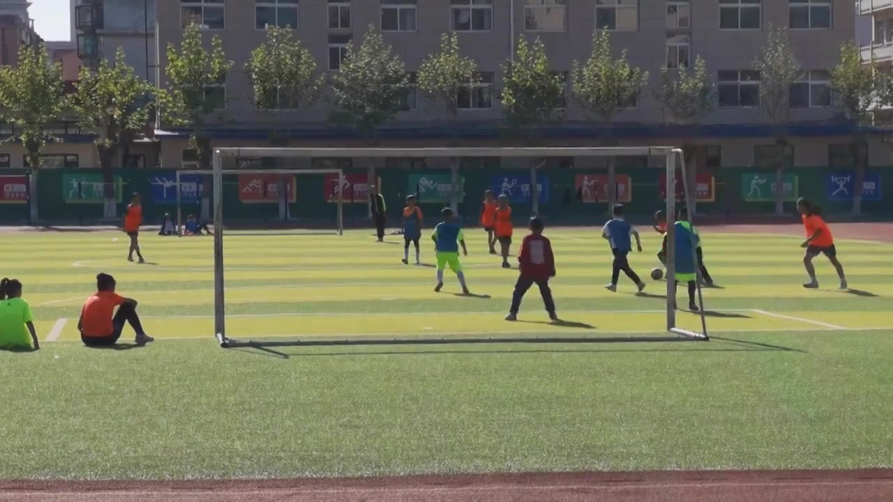 小学里正在练习踢球的学生们男女混合视频下载