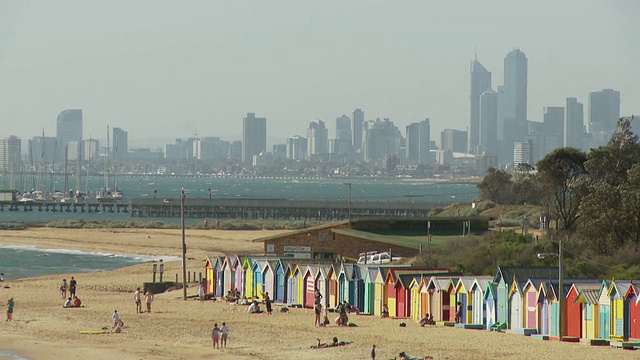 澳大利亚墨尔本，布莱顿海滩，以市中心天际线为背景的一排色彩丰富的海滩小屋视频素材