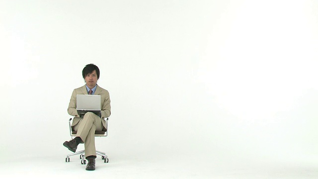 商人坐在椅子上，使用笔记本电脑视频素材