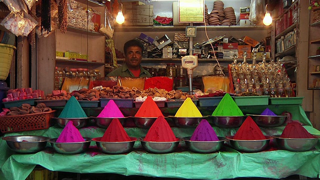 印度拉贾斯坦邦斋浦尔，一名男子坐在卖鲜艳香料的摊位后面视频下载