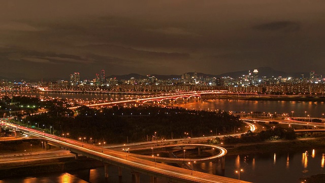 从白天到晚上，清大坝大桥上的交通与城市天际线相望/韩国首尔视频素材