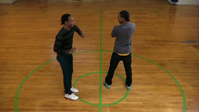 两名年轻人在篮球场上互相握手并跳舞，美国纽约视频下载