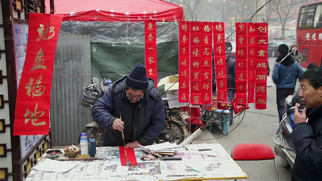 中国陕西西安，一个中国人在街道市场写春联视频素材