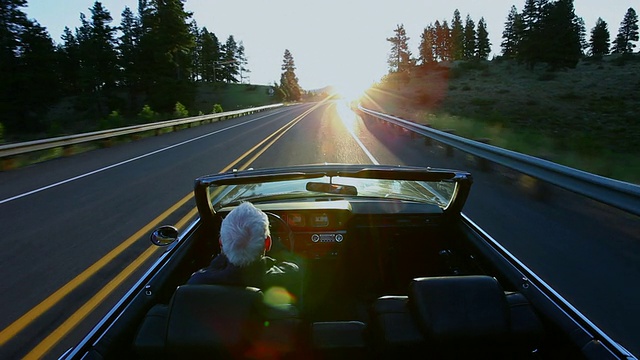 日出时分，一位老人在美国华盛顿的乡村道路上驾驶敞篷车视频素材