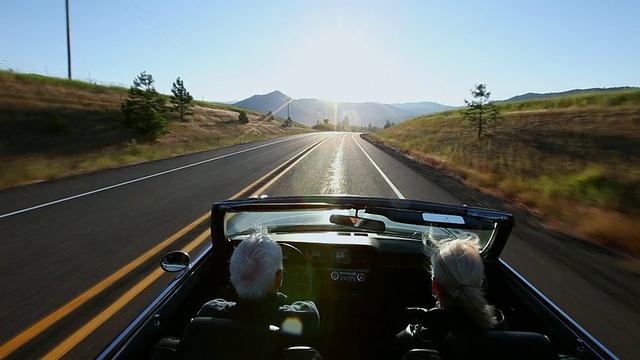 日出时分，一对老年夫妇在美国华盛顿的乡村道路上驾驶敞篷车视频素材