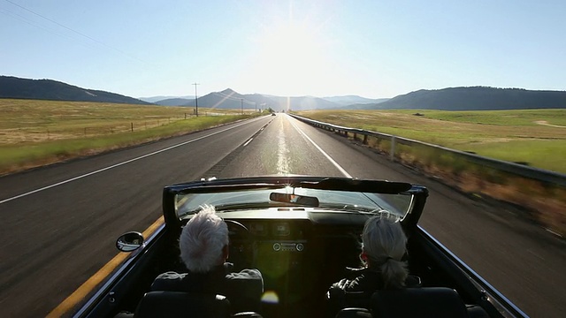 日出时分，一对老年夫妇在美国华盛顿的乡村道路上驾驶敞篷车视频下载