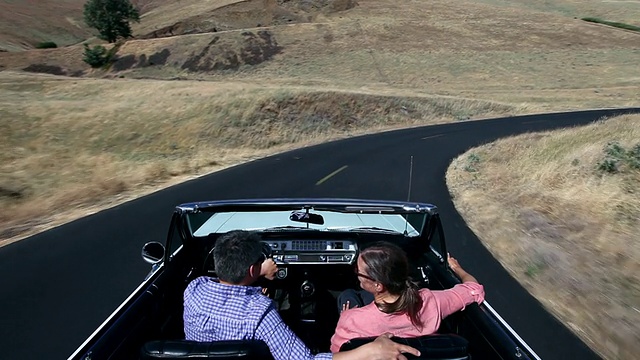 美国华盛顿，一对成熟的夫妇在沙漠中驾驶敞篷车，路上空空如也视频素材