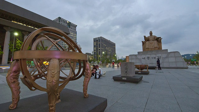 在韩国首尔市中心的光华门广场，人们在Honcheonui(一个天体)和世宗国王雕像前移动视频素材