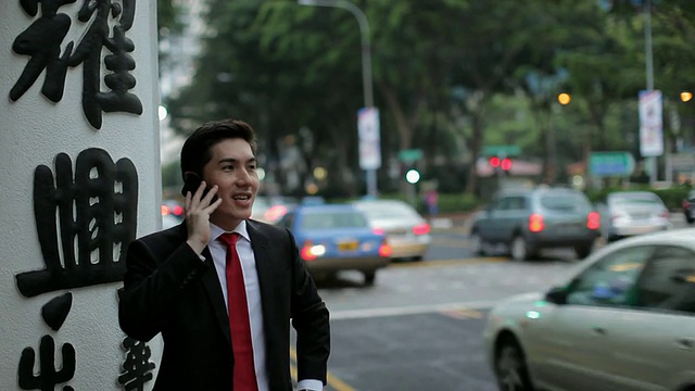 新加坡，MH商人站在繁忙的街道上打电话视频素材