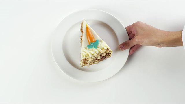 美国内布拉斯加州奥马哈市，一名女子手持白色盘子，摆着一片胡萝卜蛋糕甜点视频下载