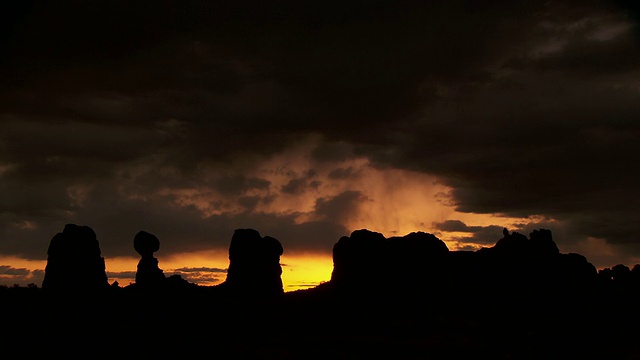 平衡的岩石和其他形成的轮廓对戏剧性的沙漠日落潘视频素材
