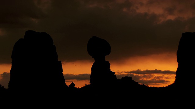 平衡岩石的剪影对戏剧性的沙漠日落视频素材
