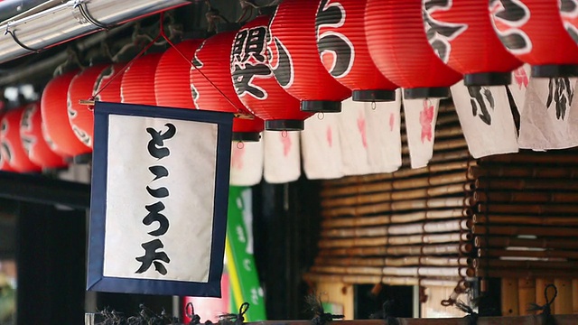 在日本京都岚山的Sweet taste商店，旗子和纸灯笼被风摇动视频素材