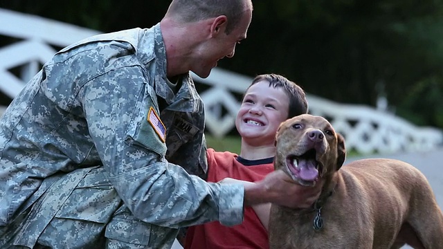 儿子和狗向从军队服役归来的士兵打招呼/里士满，弗吉尼亚州，美国视频下载