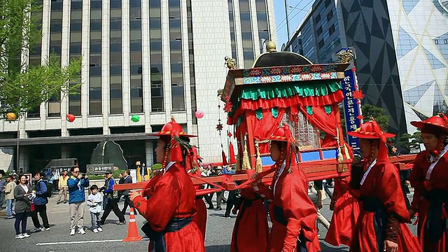 MS TS韩国首尔，传统的韩国服饰游行队伍抬着轿子穿过市政厅广场视频下载