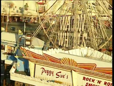 在布莱克浦码头上的摩天轮和娱乐设施周围的轨道视频下载