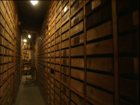 在地下室昏暗的储藏室里，向下倾斜，沿着一排排的木抽屉摆出平底锅视频素材