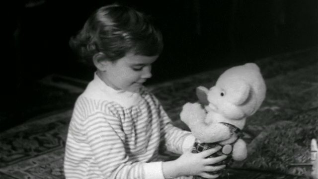 1960年，年轻女孩在圣诞节/新闻短片中玩玩具熊视频素材