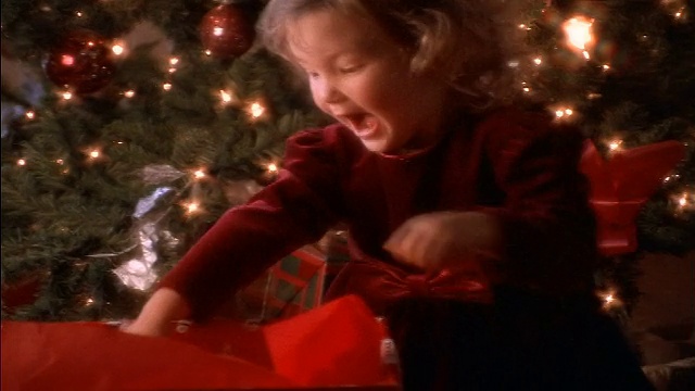 小女孩在圣诞树旁打开礼物+兴奋地掏出泰迪熊视频素材