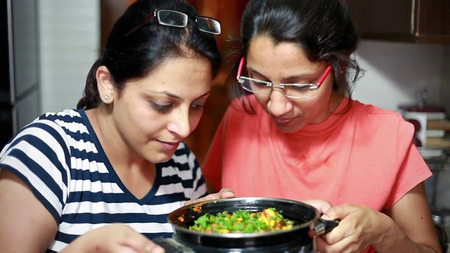 印度的家庭主妇，女人闻到并欣赏她们做的食物视频素材