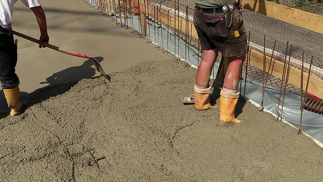 在德国莱茵兰-普法尔茨的赫尔梅斯凯尔的建筑工地上，工人们正在水泥层上施工视频素材