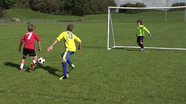 男孩得分在儿童足球/足球，慢动作视频下载