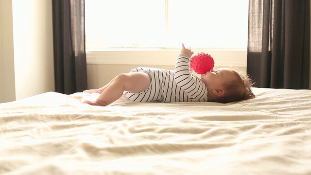 一个在家里玩球和玩具的婴儿。视频素材