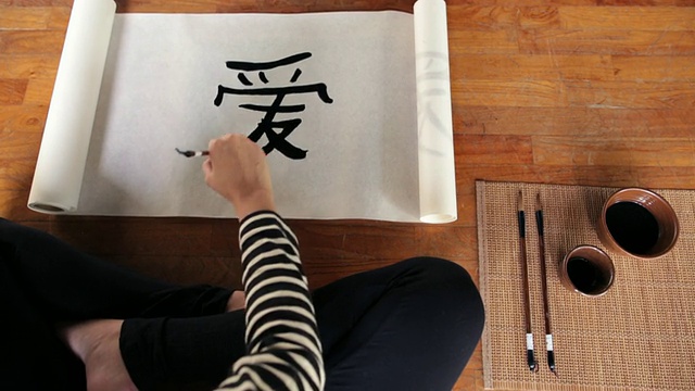 一名年轻女子在工作室里书写中国书法作品视频素材