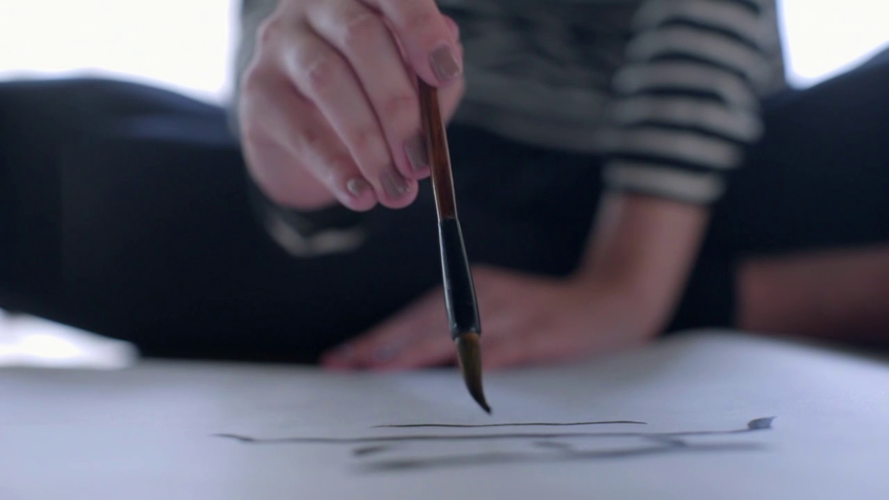 CU年轻女子用毛笔书写书法视频素材