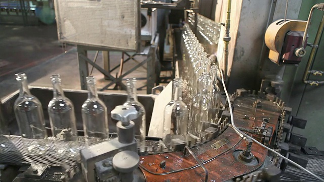 玻璃工厂。瓶子被安置在弯曲的传送带上。视频下载