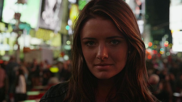 近距离的肖像严肃的年轻女子在时代广场晚上/纽约，纽约，美国视频素材