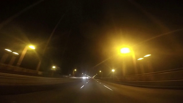 一辆车在晚上驶过金门大桥。视频素材