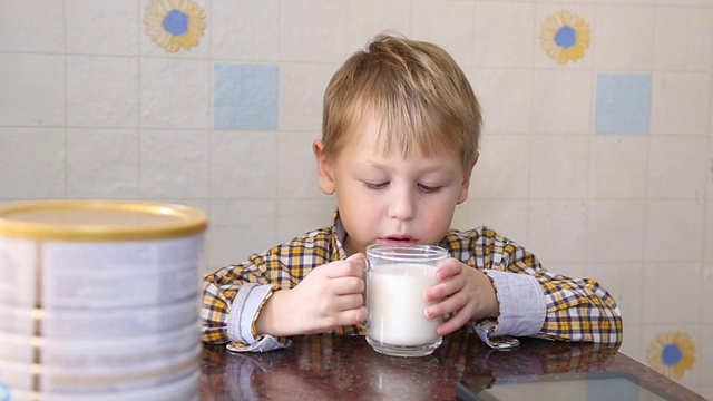 有趣的孩子高兴地喝奶粉视频素材