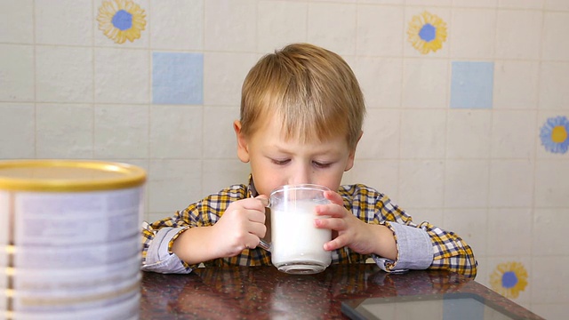 有趣的孩子高兴地喝奶粉视频素材