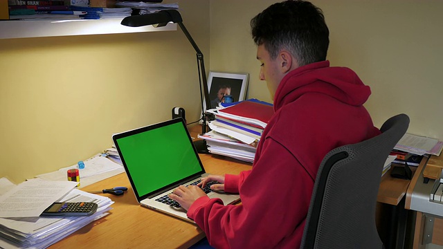 青少年在绿色屏幕的笔记本电脑上打字视频下载