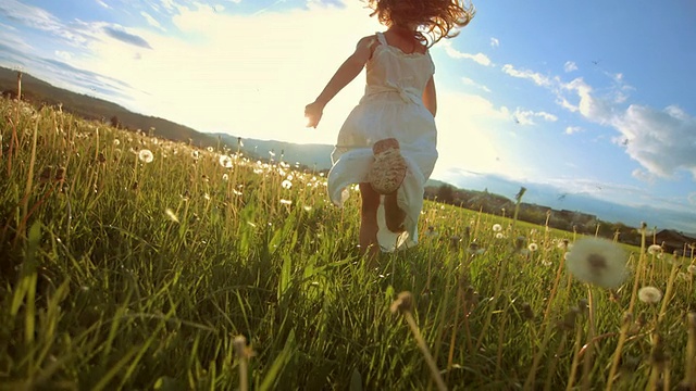 《日落草地上奔跑的超級慢動作女孩》視頻素材
