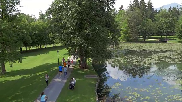 空中家庭沿着湖边跑过公园视频素材