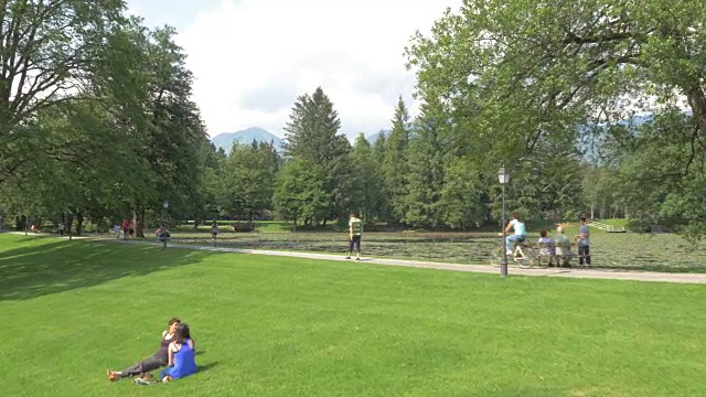 一对情侣沿着湖边跑过繁忙的公园视频素材
