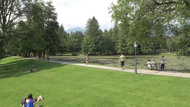 空中女子在一个繁忙的公园里沿着湖边慢跑视频素材