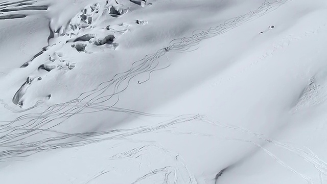 一组空中滑雪者沿着法国Haut savoir的chamonix巨大冰川而下视频素材