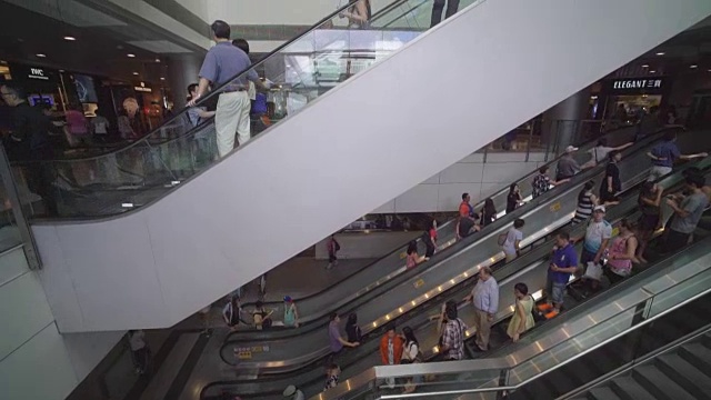 人们在购物中心的自动扶梯上移动视频下载