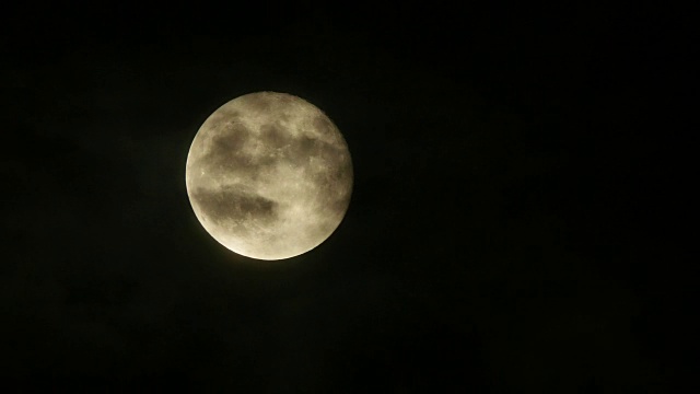 满月在多云的夜空升起的特写视频素材