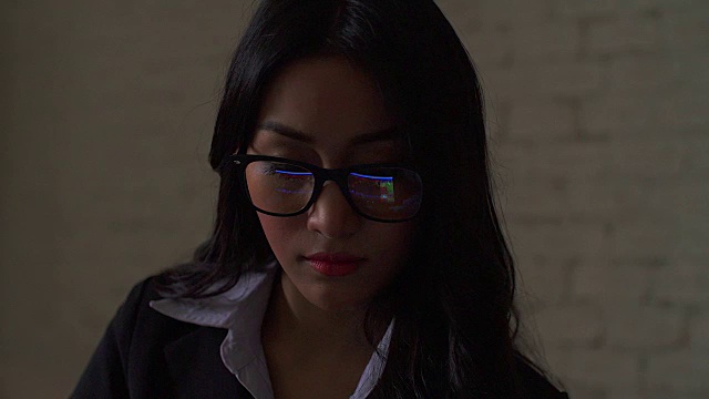 4K:亚洲女商人戴着眼镜看平板电脑上的图表视频下载