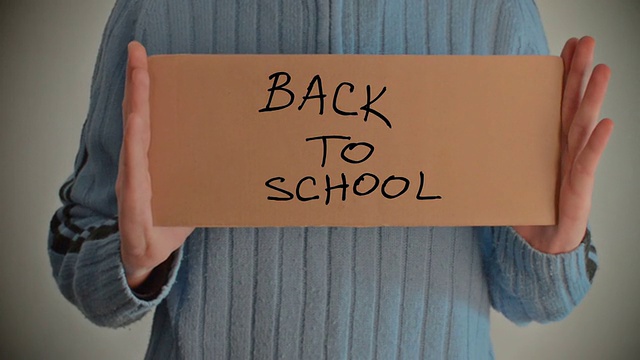 “回到学校”的信息写在硬纸板上视频素材
