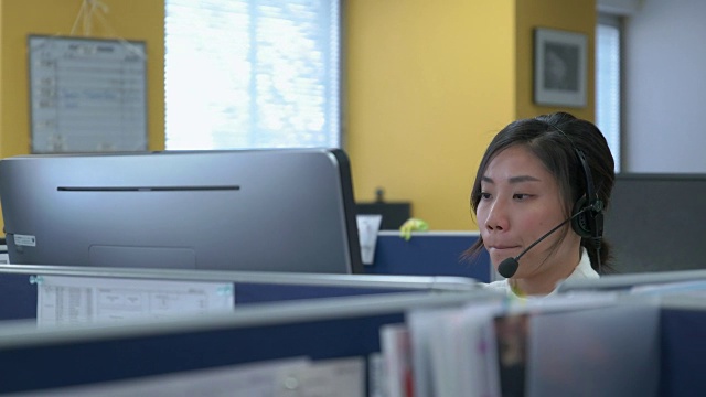 一名日本女性用4K耳机与客户交谈。视频素材