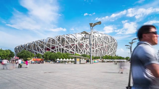 北京鸟巢体育场和广场上忙碌的人们。间隔拍摄4 k视频购买
