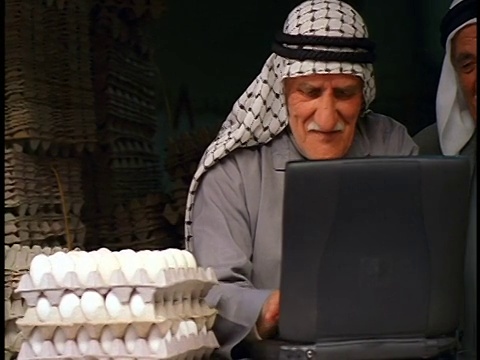 耶路撒冷露天市场摊位上，两名阿拉伯高级鸡蛋小贩在笔记本电脑上打字视频下载