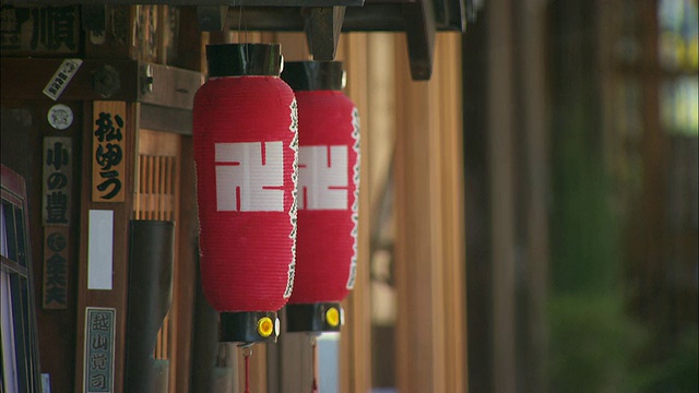 传统灯笼在京都一幢建筑外随风摇摆。视频素材