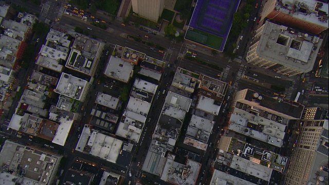 空中拍摄——太阳刚落山，这是一幅垂直跟踪拍摄曼哈顿下城的建筑和交通状况的照片。视频下载