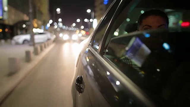 白人年轻女子享受公路旅行在城市的夜晚。视频下载